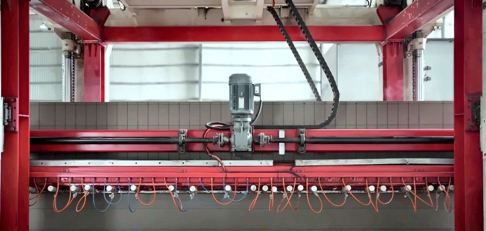 The automatic gantry cutting the green cake with wires